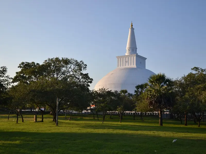 De witte stoepa Ruwanwelisaya tussen de bomen van Anuradhapura