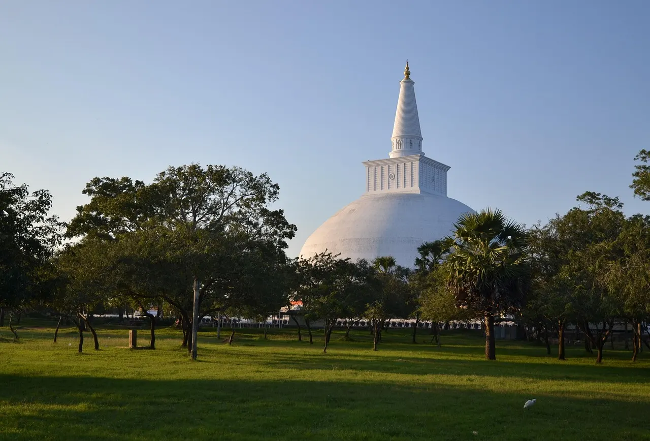 De witte stoepa Ruwanwelisaya tussen de bomen van Anuradhapura