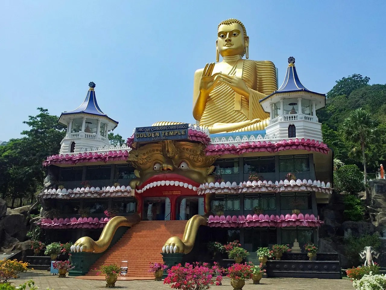 Het gouden Boeddhabeeld boven de ingang van het tempelcomplex bij Dambulla