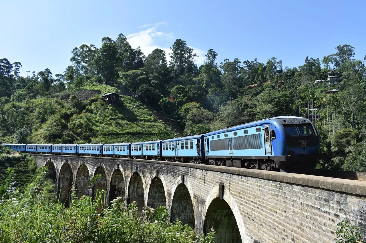 Een blauwe trein op de Nine Arch Bridge bij Ella